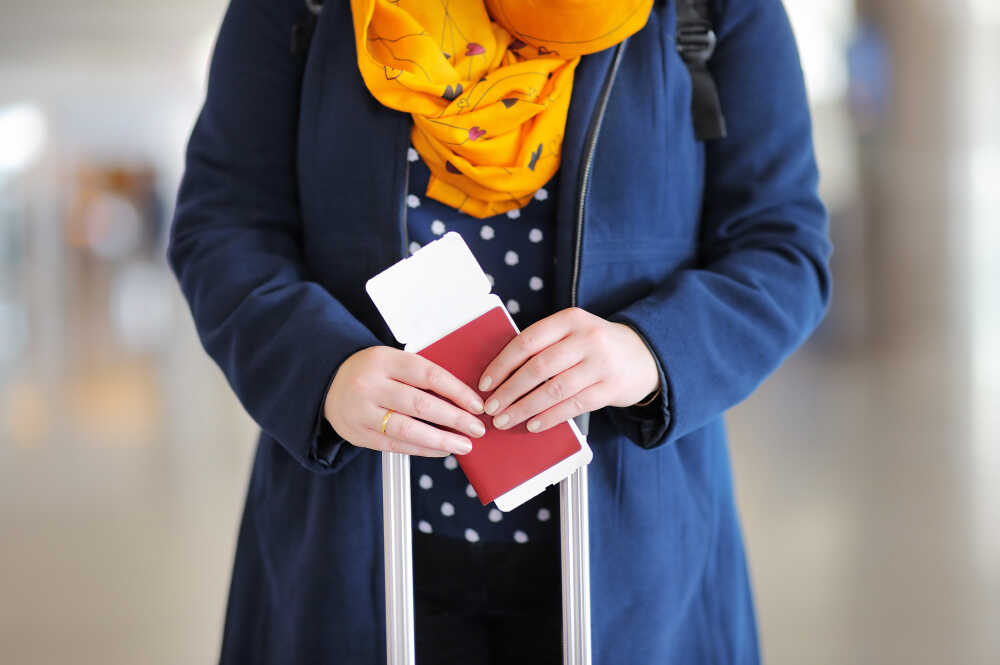 kobieta z walizką i biletem w ręku